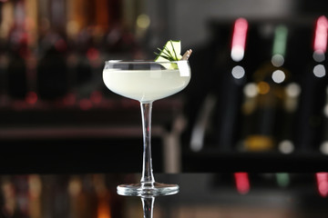 Glass of tasty cucumber martini on bar counter