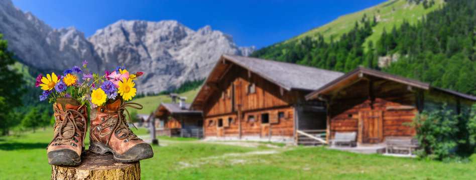 Wanderschuhe mit Blumen in sch&ouml;ner bayerischer Landschaft