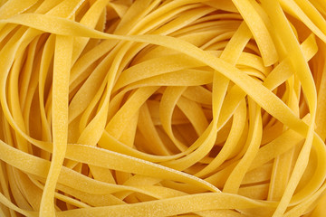 Tasty raw egg noodles as background, top view