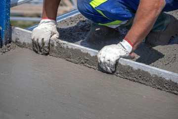 Worker straighten and smoothing fresh concrete on a construction site