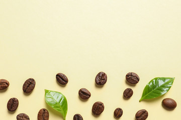 Fresh green coffee leaves and beans on light yellow background, flat lay. Space for text