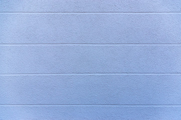 Ausschnitt Fassade als Hintergrund eines Hauses mit blauem Verputz und horizontal verlaufenden Sichtfugen als Gestaltungselement