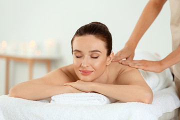 Obraz na płótnie Canvas Beautiful young woman enjoying massage in spa salon