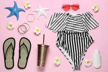 Flat lay composition with women's swimsuit on pink background