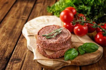 Top view of two raw vegan patties on brown rustic background