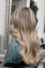 Fototapeta na wymiar Blonde girl with long hair with wave hairstyle