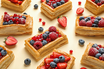 Fresh delicious puff pastry with sweet berries on beige background