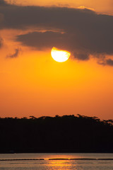Natural Sunset Sunrise Over Field Or Meadow. Bright Dramatic Sky And Dark Ground. Countryside Landscape Under Scenic Colorful Sky At Sunset Dawn Sunrise. Sun Over Skyline, Horizon. Warm Colours.