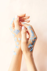 Gentle elegant female hands with manicure in flower petals.
