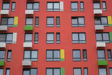 modern red facade of a multi-storey residential building, windows