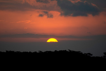 Natural Sunset Sunrise Over Field Or Meadow. Bright Dramatic Sky And Dark Ground. Countryside Landscape Under Scenic Colorful Sky At Sunset Dawn Sunrise. Sun Over Skyline, Horizon. Warm Colours.