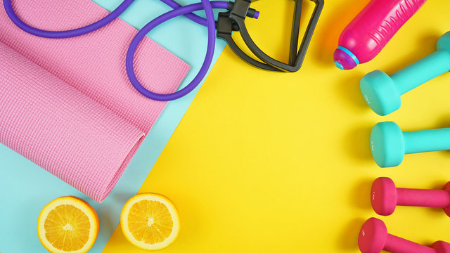 Health and fitness concept flatlay with exercise equipment on modern colorful background with copy space.