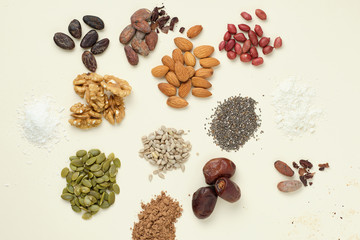Various superfoods top view. Superfood as coconut powder, spirulina, raw cocoa bean, kerob, walnut, peanut, sunflower and pumpkin seeds.