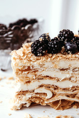 Homemade Napoleon Cake with blackberry. Menu for cafe, delicious puff dessert. Section, texture, closeup. Vertical photo.