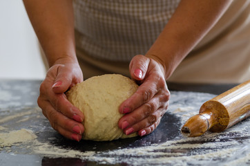 The woman is kneading  the dough.