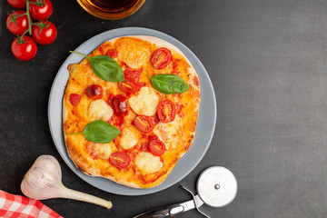 Pizza with Mozzarella, halved Cherry Tomatoes, Spices and Fresh basil