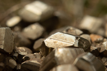 Macro closeup of pyrite mineral with mirror-bright, golden striated cubes