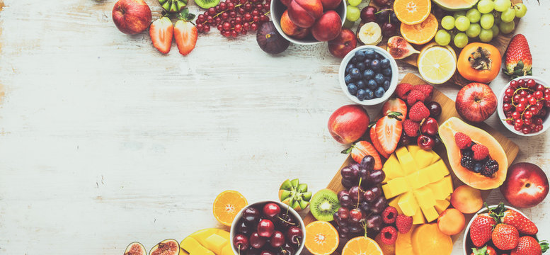 Healthy Raw Fruits Background, Cut Mango Papaya, Strawberries Raspberries Oranges Plums Apples Kiwis Grapes Blueberries Cherries, On White Table, Copy Space, Top View, Toned, Banner, Selective Focus