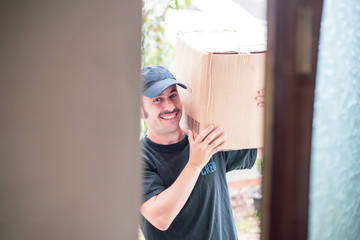 A delivery man with a prominent mustache and a blue hat delivering a generic brown box in front of someones house door