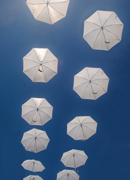 Guarda-chuvas a voar no c&eacute;u em linhas paralelas