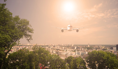 The plane over the city and plants. sunset.