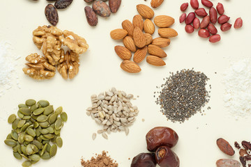 Various superfoods top view. Superfood as coconut powder, spirulina, raw cocoa bean, kerob, walnut, peanut, sunflower and pumpkin seeds.