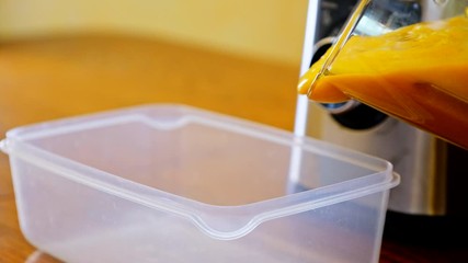 Making peach smoothie in blender jar and pouring it in container box. Preparing fresh drink with juice machine in home kitchen. Healthy eating detox lifestyle. Mixing fruit close up. - Powered by Adobe