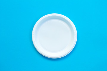 White plastic plate on blue background.