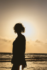 Fototapeta premium silhouette of woman on the beach at sunset