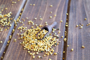 Bee pollen grains in wooden spoon