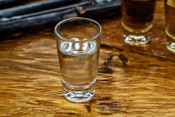 Several glasses of brazilian cachaça isolated on rustic wooden background, variations and types of brazil cachaça, typical drink from brazil.