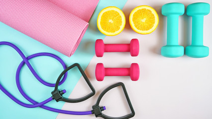 Health and fitness concept flatlay with exercise equipment on modern colorful background with copy...