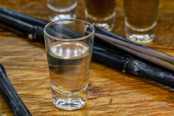 A glass of brazilian cachaça isolated on rustic wooden background, bar drink.