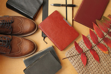 Autumn seasonal fashionable flat with autumn leaves, books and men's shoes in autumn colors