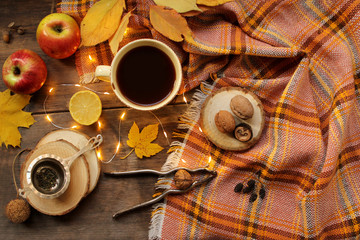 flat of dry autumn leaves, candles, tea, coffee, nuts on a wooden background