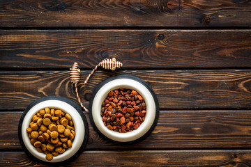 Cat food in bowl and toys on wooden background top view copyspace