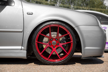 red candy colored light alloy wheels on silver hatchback