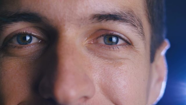 Close up eyes of young happy man looking into camera lens. Close-up of a male eyes.