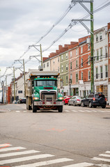 Fototapeta na wymiar Green big rig tip truck running on the city street