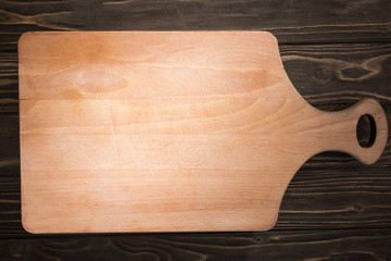 top view of wooden cutting board on brown table