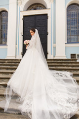 Obraz premium Wedding dress. beautiful bride holding wedding bouquet near church
