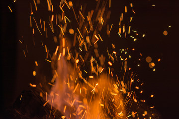Fototapeta na wymiar Background of fire sparks exploding at night in a bonfire
