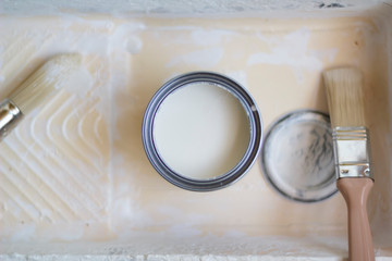 Opened can of white and paint brushes. Top view