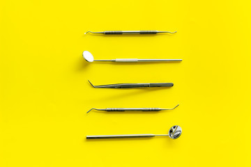 dentist desk with instruments on yellow background top view