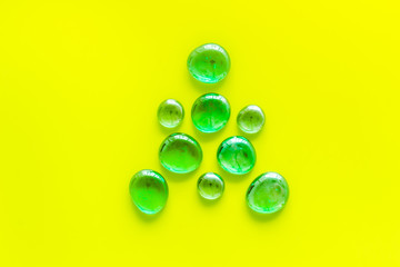 Glass stones for design and home creativity on yellow background top view