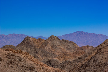 steep and sharp rocky mountain desert wilderness scenery landscape wallpaper pattern picture with empty blue sky background and space for copy or text 