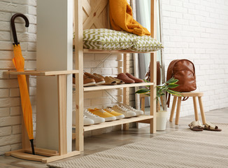 Cozy hallway interior with wooden shelving unit. Stylish design idea