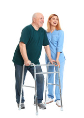 Caretaker helping elderly man with walking frame on white background