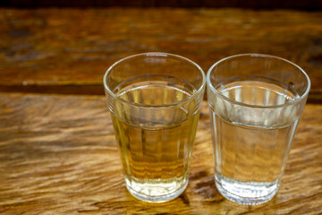 Several glasses of brazilian cachaça isolated on rustic wooden background, variations and types of brazil cachaça, typical drink from brazil.