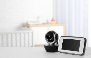 Baby monitor with camera on table in room, space for text. Video nanny